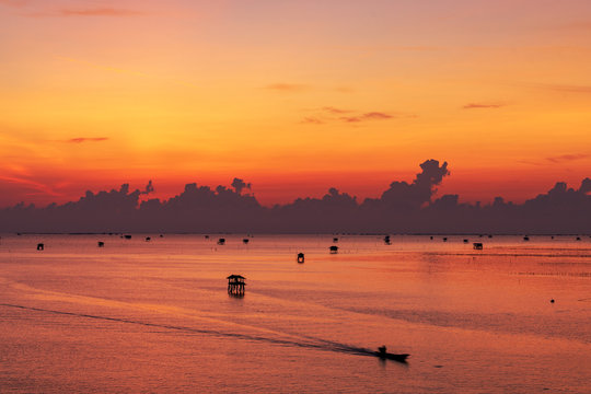 Fototapeta scenic of sunrise sky and seascape with silhouette cottage