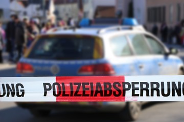 Polizeiabsperrung mit Polizeiauto im Hintergrund