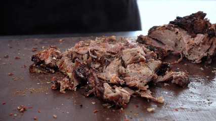Chef cuts lamb or beef meat, cooked on the grill. Sprinkles with spices.