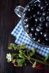 Close-up of bilberries in a glass cup against the dark background