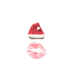 Christmas card concept: red Santa's hat above a lip print on a white isolated background