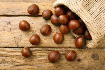 marroni o castagne crude su tavolo di legno rustico
