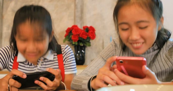 cheerful asian teenager playing entertainment on smart phone with happiness emotion