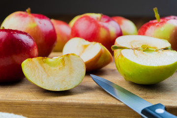 Close-up of ripe juicy apples on wooden table. Home grown organic apples and knife on rustic table background