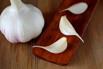 Garlic head and cloves. Fresh harvest on a wooden table