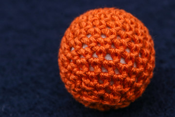 esfera de lana naranja en fondo azul
