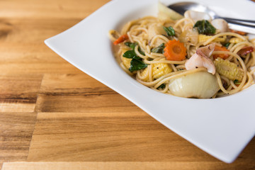 Spaghetti Stir Fried Sea Bass on wooden table