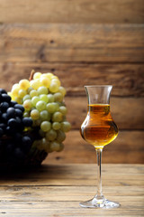 grappa disitllato di uva in bicchiere di vetro sfondo rustico