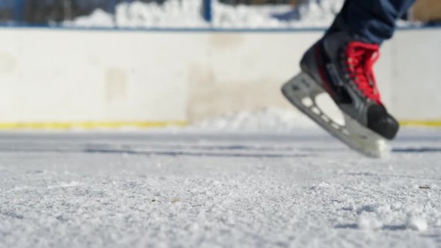 CLOSE- UP: Man ice skating and stopping