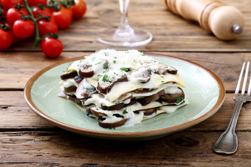 lasagne con funghi e besciamella su sfondo rustico