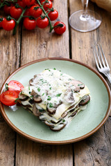 lasagne con funghi e besciamella su sfondo rustico