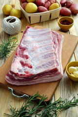 carne di porco cruda costolette e petto su tagliere di legno