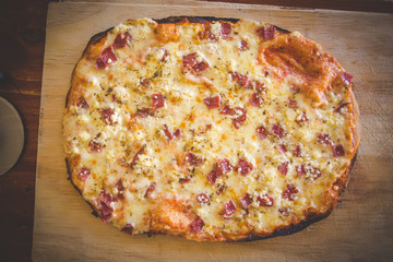 Close up image of a freshly baked gourmet wood fired pizza as it gets taken out of the pizza oven