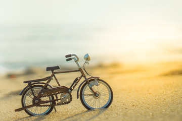 bicycle transport toy on sand sea beach in the evening sunset sky , with yellow light beam