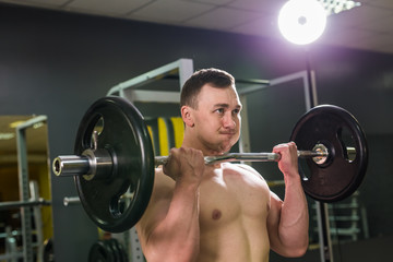 Naklejka na ściany i meble Handsome power athletic man with barbell. Strong bodybuilder with six pack, perfect abs, shoulders, biceps, triceps and chest