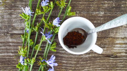 Ground chicory and chicory flowers on wooden background.