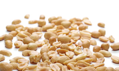 Fried and salted peanuts pile isolated on white background and texture