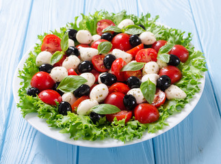 Salad with basil , tomatoes , olives and mozzarella
