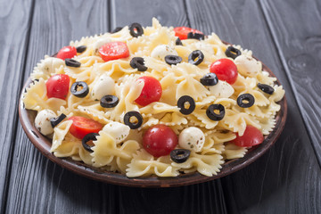 Pasta salad with mozzarella , olives and tomatoes
