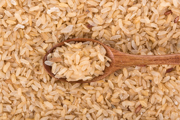 pounded unripe rice in wooden spoon