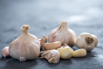 Group of garlic cloves scattered on a dark background. Important ingredient in different cuisines of the world