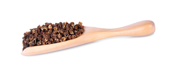 Dry Zanthozylum limonella Alston in wooden spoon on white background.