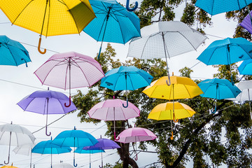 Fototapeta na wymiar Multi-colored umbrellas adorn the city's street during the holiday_