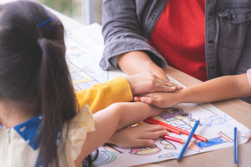 Teacher and kindergarten students hand together for teamwork