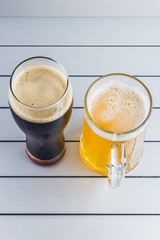 glasses of light and dark beer on aluminum panels