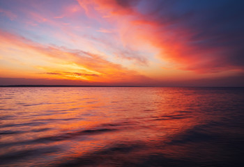 Beautiful spring landscape with sea coast, colorful sunset sky.