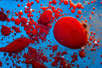 Red bubbles of blood cells on blue background. Abstraction of medicine. Concept of micro processes...