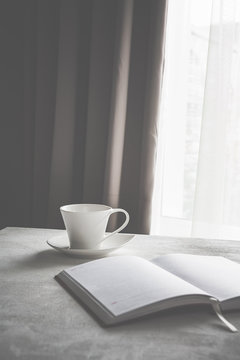 cup of coffee on a table near a window in Scandinavian style minimalism in gray scale with copy space