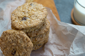 Oatmeal cookies and milk on a wooden board and gray background