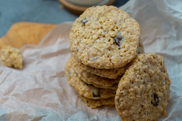 Oatmeal cookies and milk on a wooden board and gray background