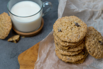 Oatmeal cookies and milk on a wooden board and gray background