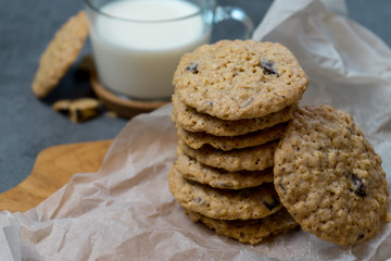 Oatmeal cookies and milk on a wooden board and gray background