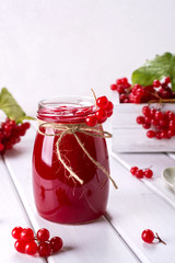 Delicious  viburnum jam with fresh berries on white table.