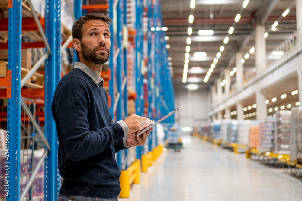 Wall mural Manager in warehouse holding digital tablet