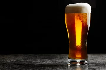Selbstklebende Fototapete Bier Glas kaltes helles Craft-Bier auf dunklem Hintergrund..