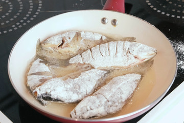 Fish carps fried in oil in a pan.