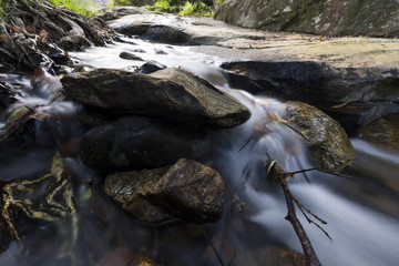 Fototapeta na wymiar Landscape of small waterfall cascading over a rock with a long exposure