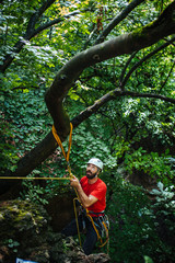 Naklejka na ściany i meble Mountain rescuer securing ropes to climb 