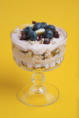 One glass cup, with granola oat meals, with dried fruits, blueberries and yogurt. Isolated on...