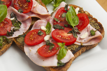 Healthy bread toast with pesto sauce, tomatoes, garlic and basil leaves. Delicious snack.