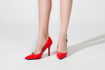 Beautiful legs of the woman in red shoes. Ideal skin. Evening high red shoes on a hairpin.