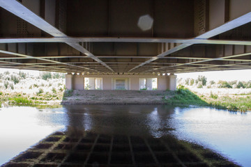 reflection of a bridge in a blue river