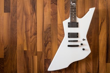 Weiße Heavy E-Gitarre auf braunem Hintergrund