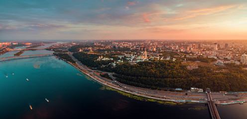 Panorama of the city of Kiev at sunset. A modern metropolis in the center of Europe against the backdrop of sunset sky from a bird's eye view. Aerial view. Panorama of the Tourist Center of Kiev. View