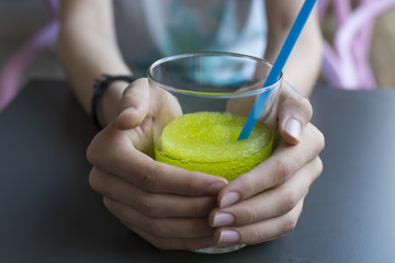 hands with glass with slush lime or green apple