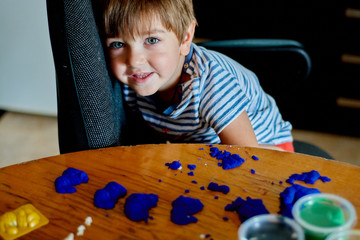 Close-up portrait of baby boy playing with kinetic sand